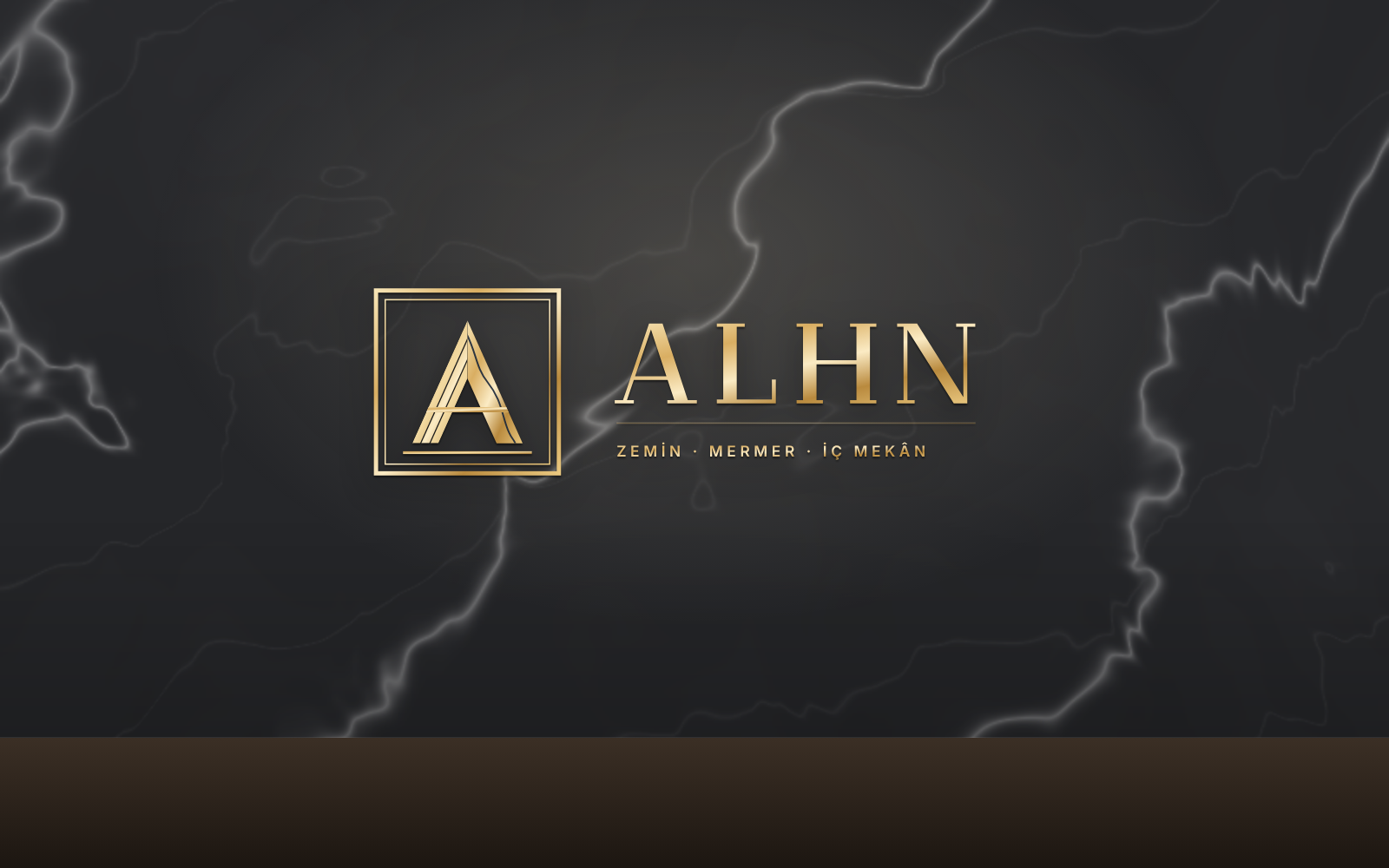 Siyah mermer duvarda pirinç harflerle ALHN logosu